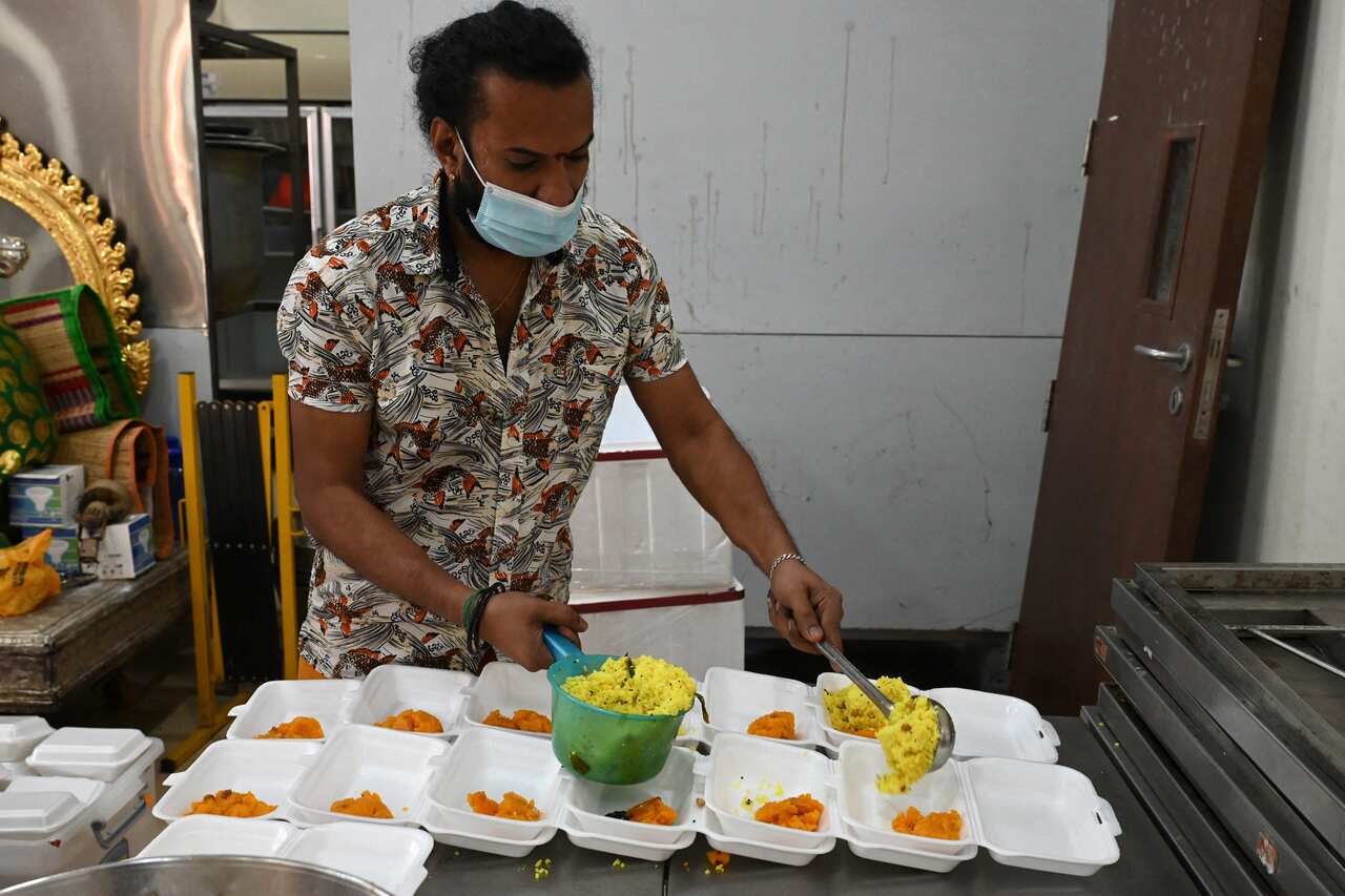A member of the Sri Veeramakaliamman temple prepares lemon rice for migrant workers visiting for prayers in the district of Little India in Singapore on September 15, 2021,