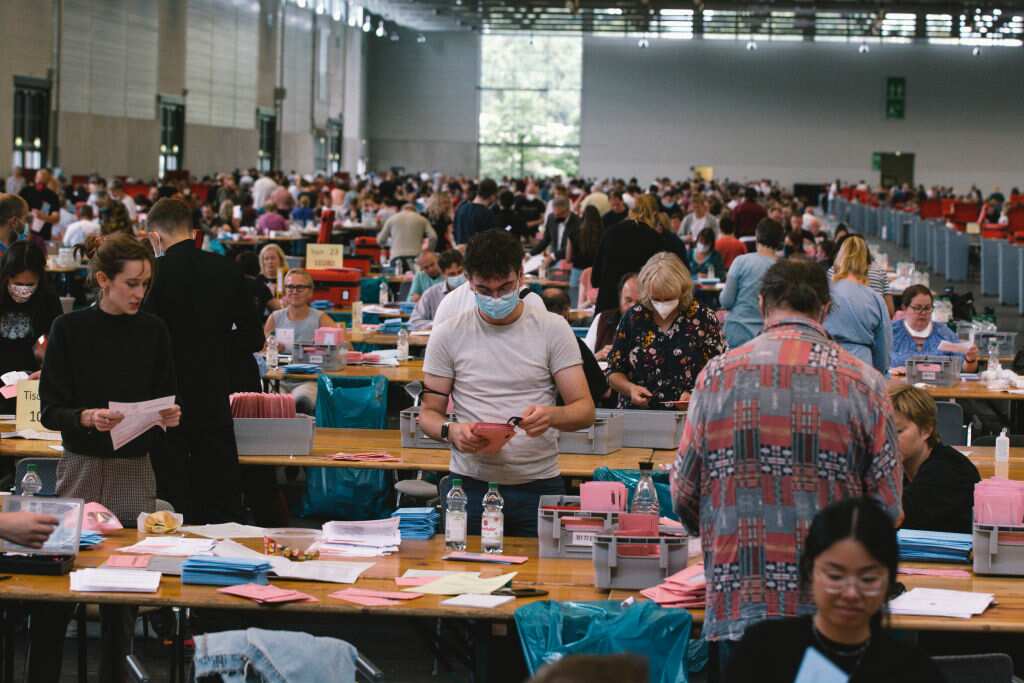 Volunteers are seen inside the Cologne Trade Fair Centre in Colognoe, Germany, on 26 September, 2021. 