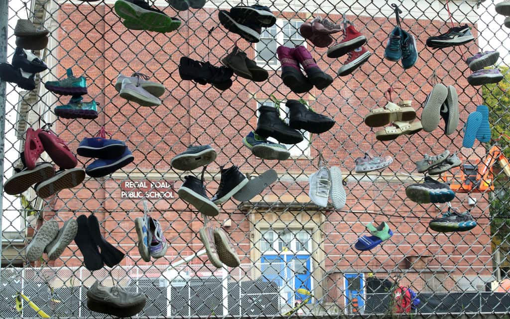 A school marks National Day of Truth and Reconciliatio in the form of shoes tied to a fence near Davenport, Canada.