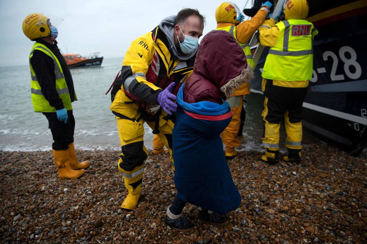 Migrants are helped ashore from  lifeboat at a beach in Dungeness, on the south-east coast of England, on 24 November, 2021.