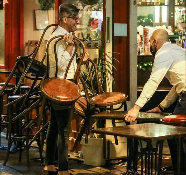 Bar workers clear tables from outside a pub on 20 December as an 8pm closing time for pubs and restaurants came into effect in Ireland.