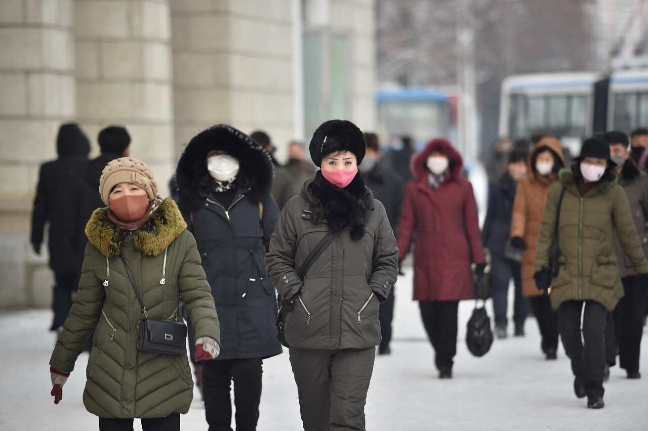 Pedestrians walk on a street near Pyongyang Railway Station after a snowfall in Pyongyang on January 19, 2022. (Photo by KIM Won Jin / AFP) (Photo by KIM WON JIN/AFP via Getty Images)