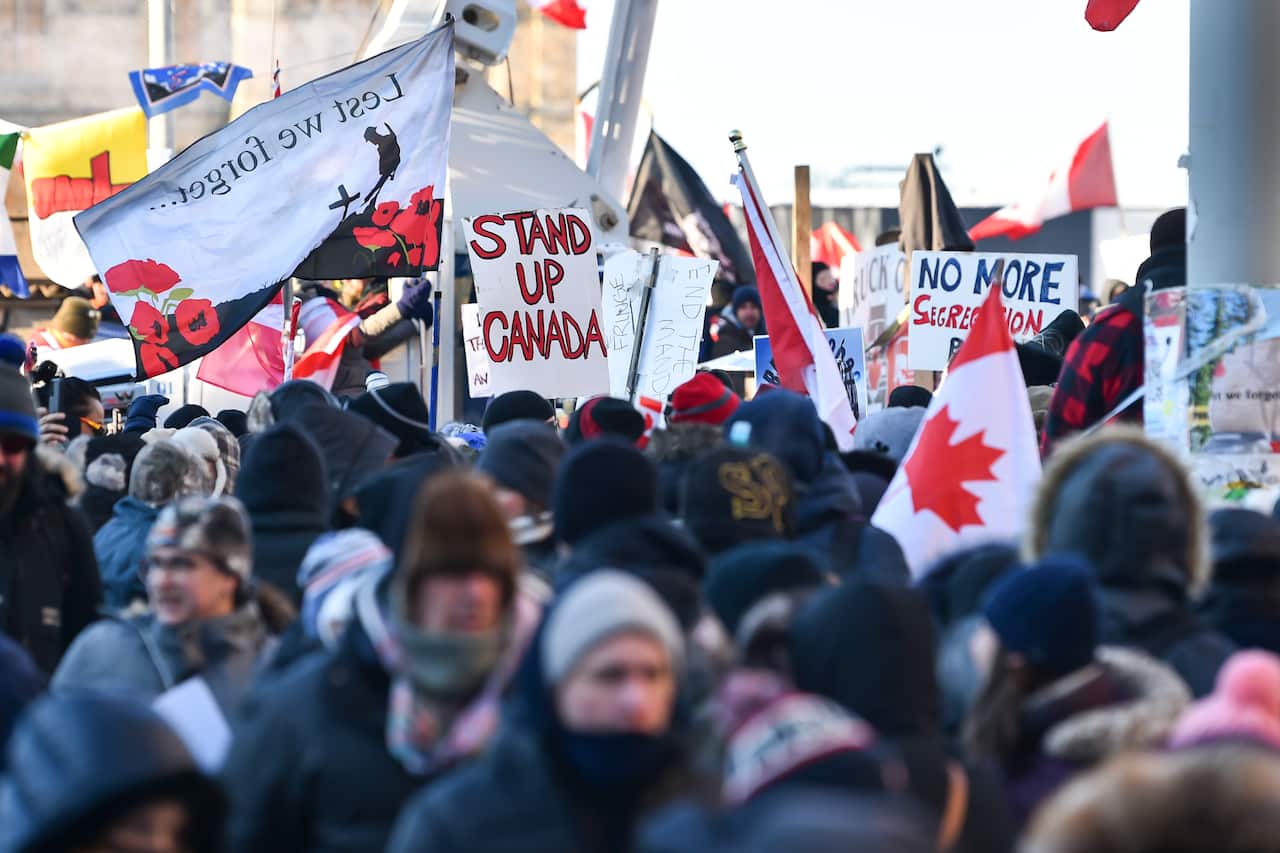 Protesters hold signs condemning the vaccine mandates imposed by Canadian Prime Minister Justin Trudeau in Ottawa, Canada