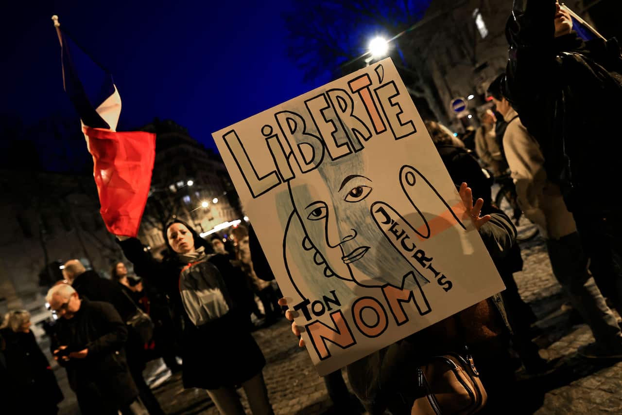 A protester holds a sign referring to the poem 'Liberte' (Freedom) during a rally in Paris on 11 February as convoys of protesters are expected to arrive.