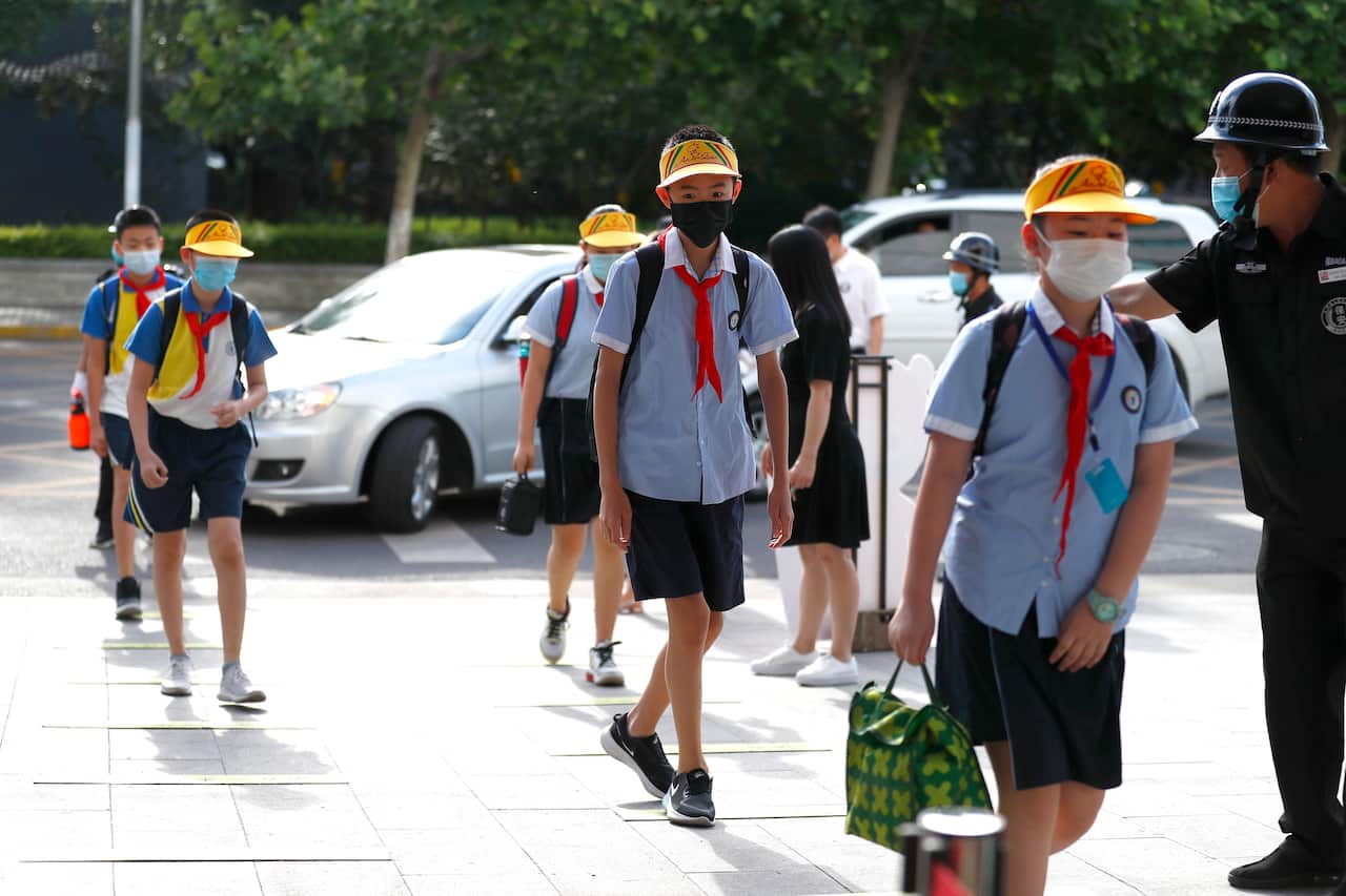 Grade 6 students wearing face masks walk to school on 1 June, 2020, in Beijing, China. 