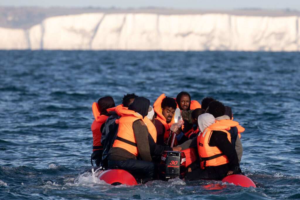 Migrants packed tightly onto a small inflatable boat attempt to cross the English Channel.