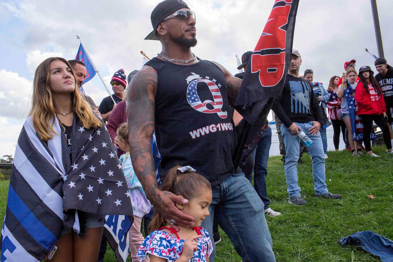 QAnon supporters attend a Trump rally