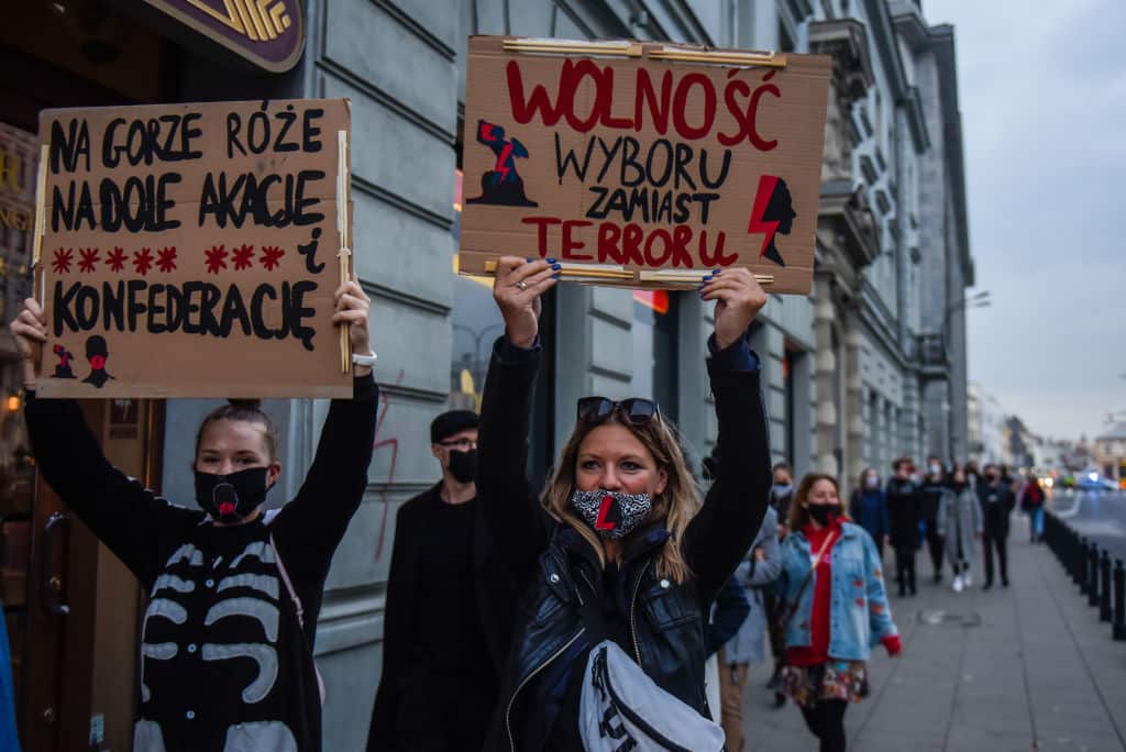 Women shout slogans and hold banners as they participate in a national strike during the seventh day of protests.