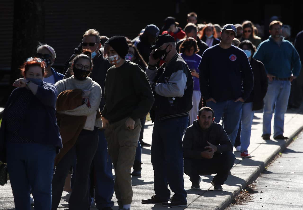 People wait in line to cast their votes at Northern High School, on 3 November, 2020 in Owings, Maryland.
