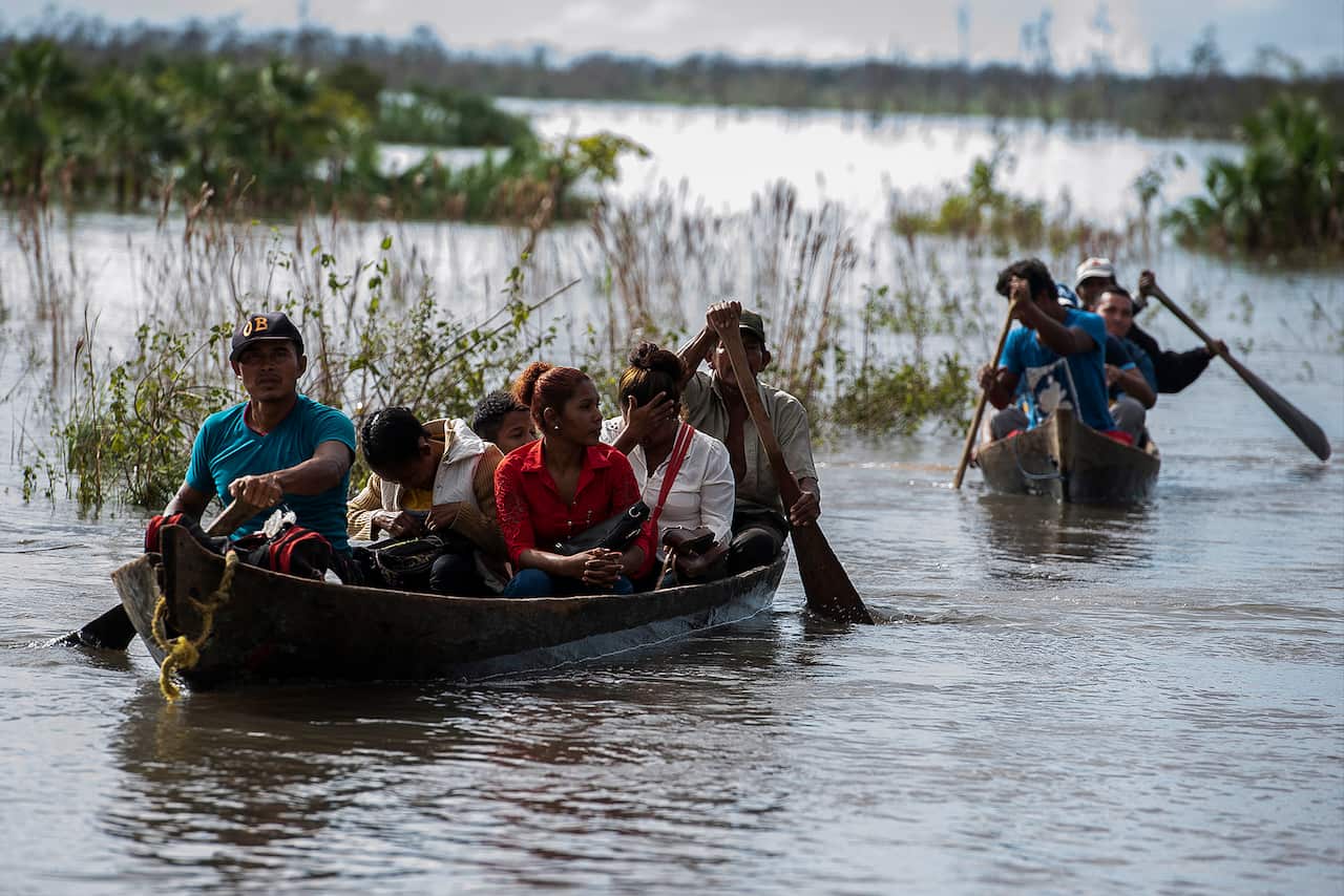 People of the Wawa Bum community are transported across the overflowed Wawa river after the passage of Hurricane Iota on 19 November in Bilwi, Nicaragua.