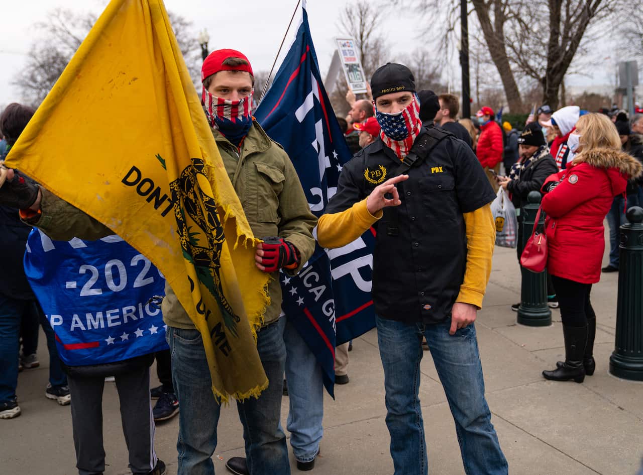 A Trump supporter flashes the 'OK' hand symbol, which has come to be associated with far-right trolls.