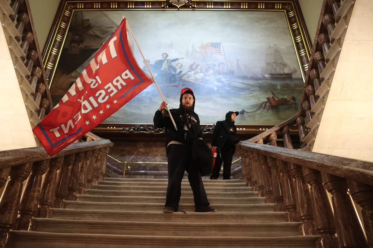 A protester holds a Trump flag inside the US Capitol Building near the Senate Chamber.