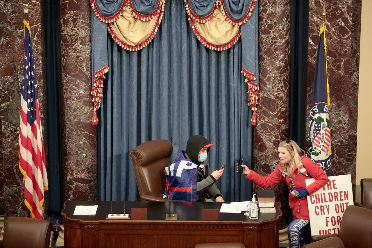 A protester sits in the Vice-President's seat in the Senate Chamber.