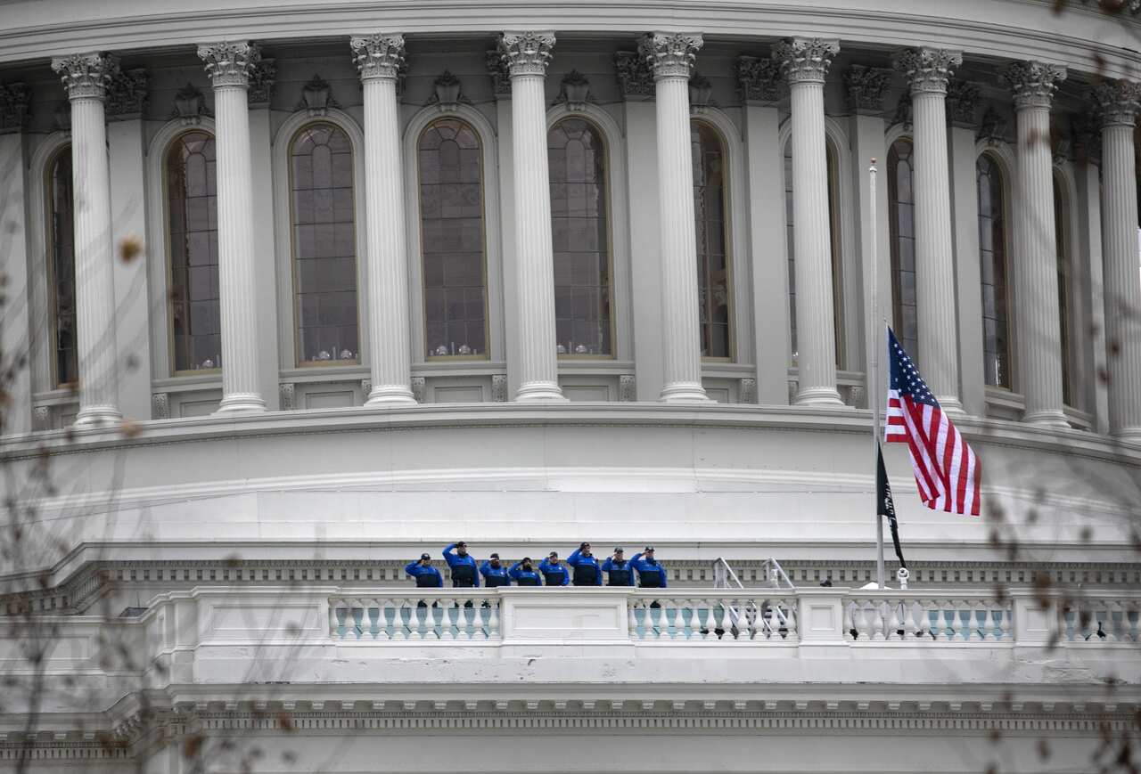 Capitol Police salute after raising the American flag to half-staff in honour of police officer Brian Sicknick on 8 January in Washington, DC.