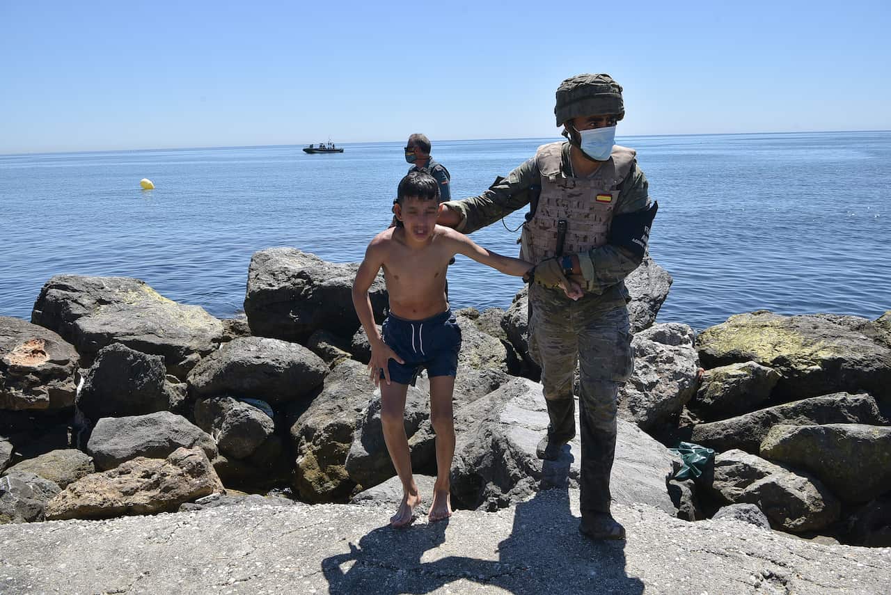 A Spanish army soldier helps a young migrant from Morocco on his arrival in Ceuta, Spain.