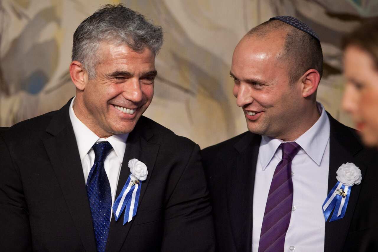 Yair Lapid (left) speaks to Naftali Bennett (right) during a reception marking the opening of the 19th Knesset (Israeli parliament) on 5 February 2013 in Israel.  
