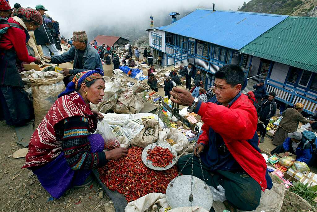 A Sherpa woman buys chili peppers at the weekly market in Namche Bazar, Nepal. 