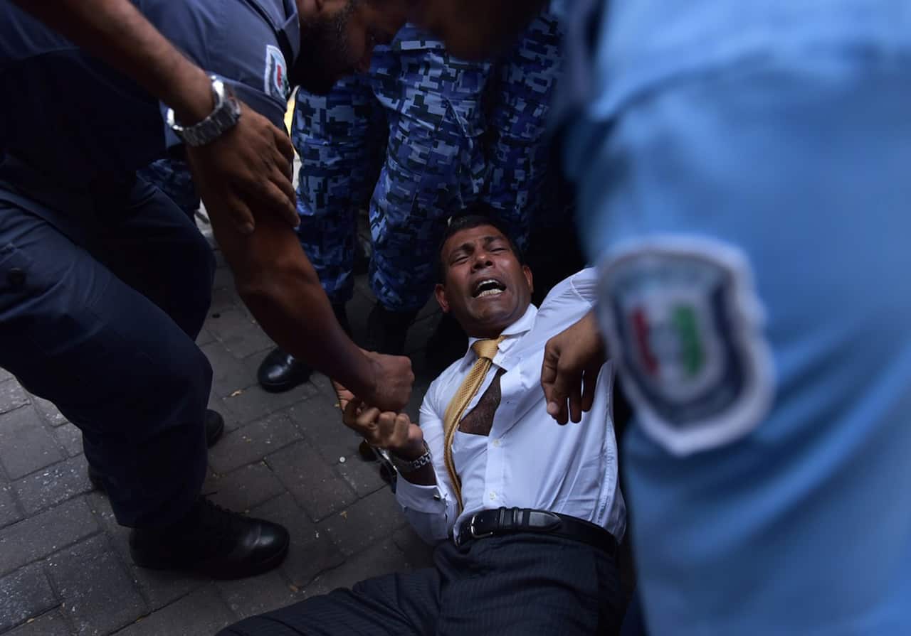 Former president Mohamed Nasheed falls to the ground during a scuffle as he arrives at a courthouse on February 23, 2015.