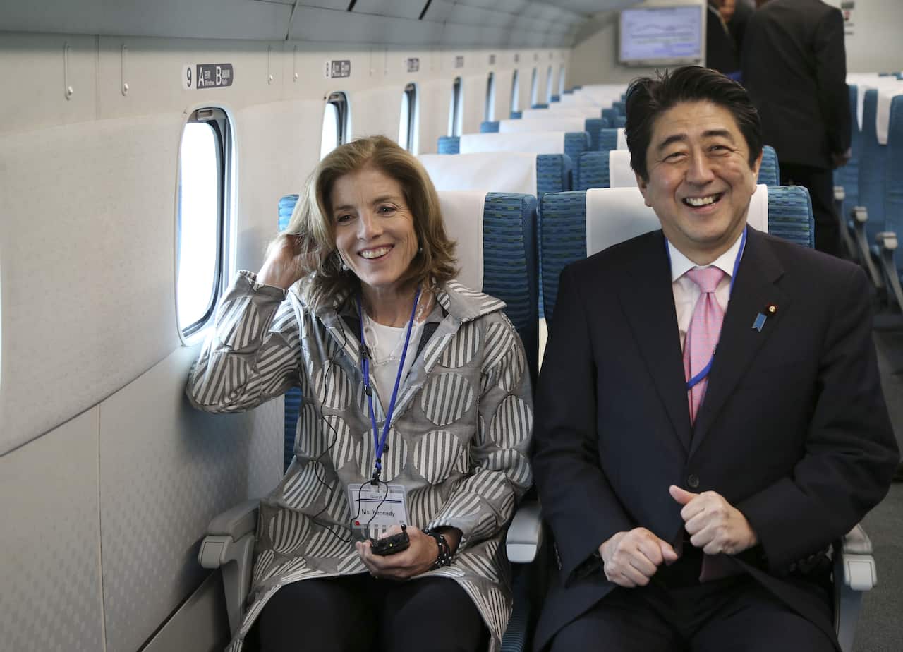 Japanese Prime Minister Shinzo Abe and US Ambassador to Japan Caroline Kennedy smile as they inspect a magnetically levitated train system during their trip to the Yamanashi Experiment Center in Tsuru, central Japan on April 12, 2014. AFP PHOTO / POOL / K