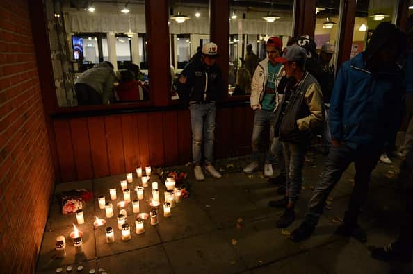 People stand next to candles at a makeshift memorial site at a school in Trollhattan, southwestern Sweden, on October 22, 2015    (Photo credit should read JONATHAN NACKSTRAND/AFP/Getty Images)