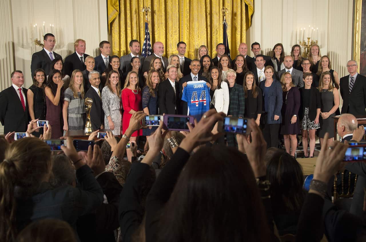PHOTO: US Women's national soccer team celebrates 2015 FIFA world cup win at the White House with then President Obama.
