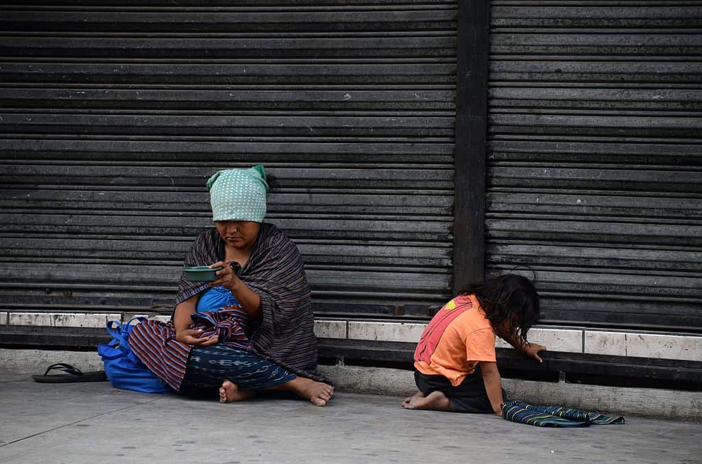 An indigenous woman with her child begs for money on the streets of the historic centre of Guatemala City, on May 31, 2014. AFP PHOTO Johan ORDONEZ        (Photo credit should read JOHAN ORDONEZ/AFP/Getty Images)