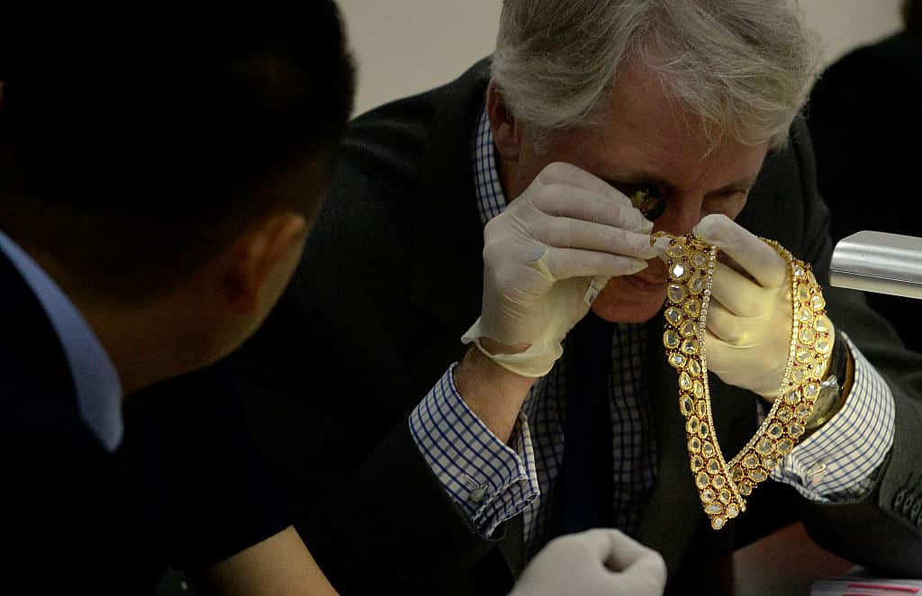 Christie's and Sotheby's auction house appraiser David Warren (R) examines diamond jewellery seized by the Philippine government from former first lady Imelda Marcos, at the Central Bank headquarters in Manila.