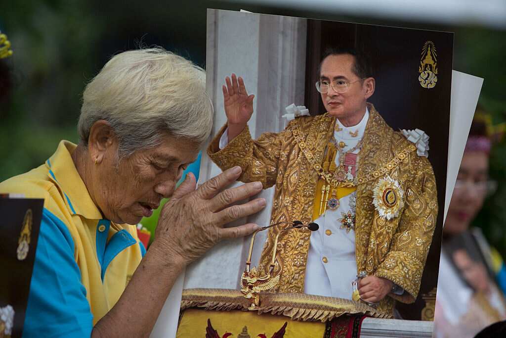 A Thai woman prays for the ailing Thailand's King Bhumibol Adulyadej