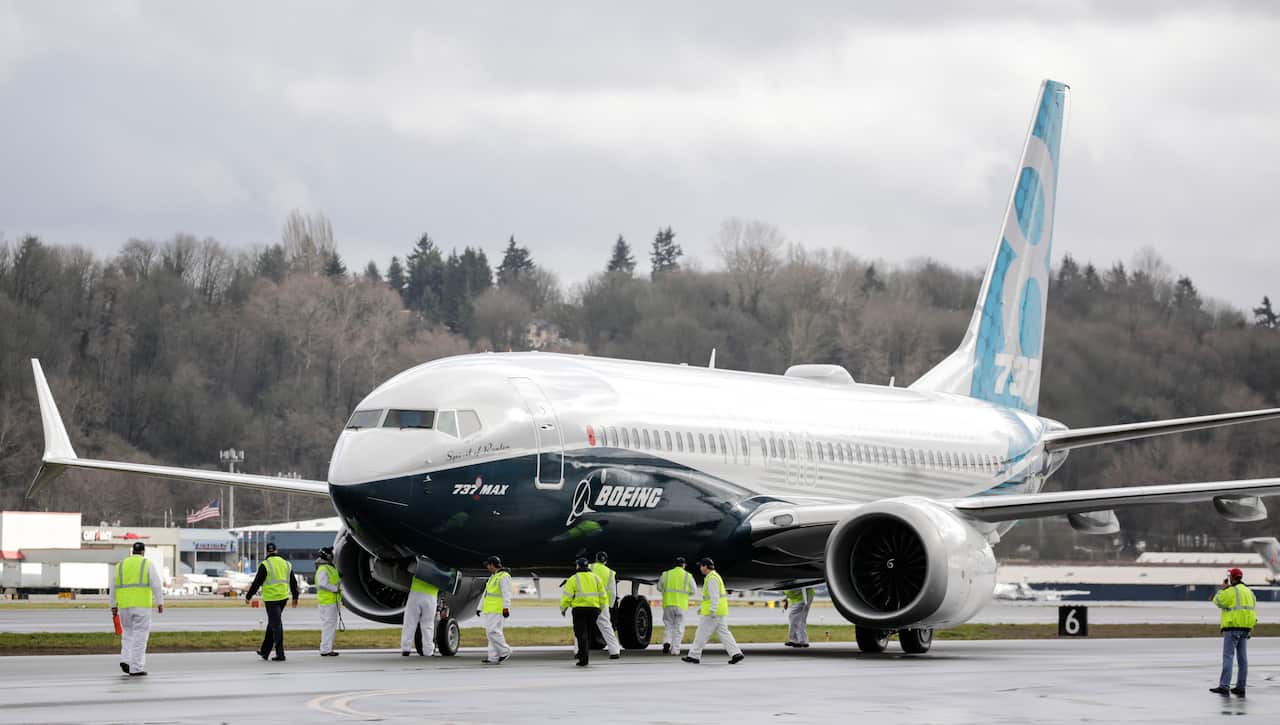 Ground crew check out a Boeing 737 MAX 8 airliner.