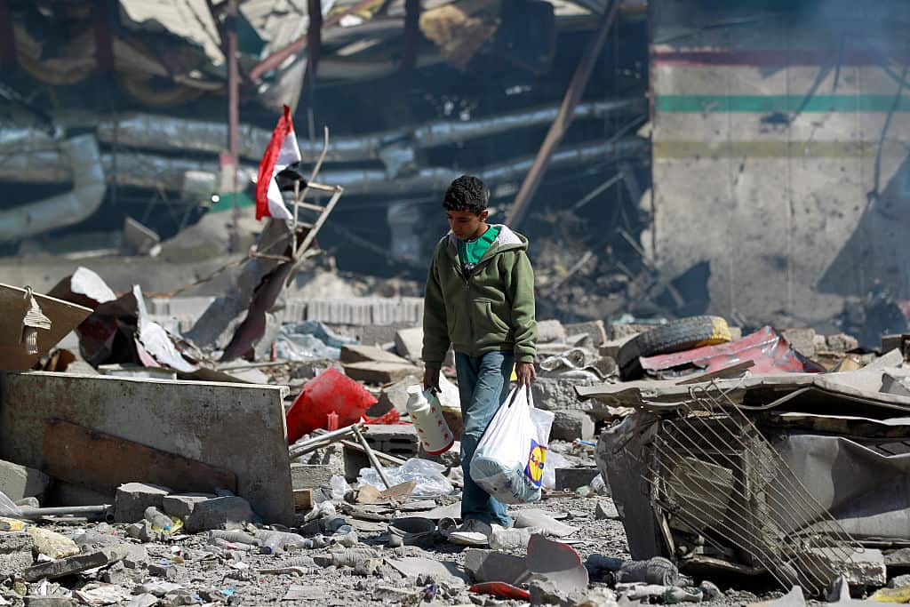 In this file photo, a Yemeni boy walks amid the ruins after an air-strike carried out by the Saudi-led coalition.