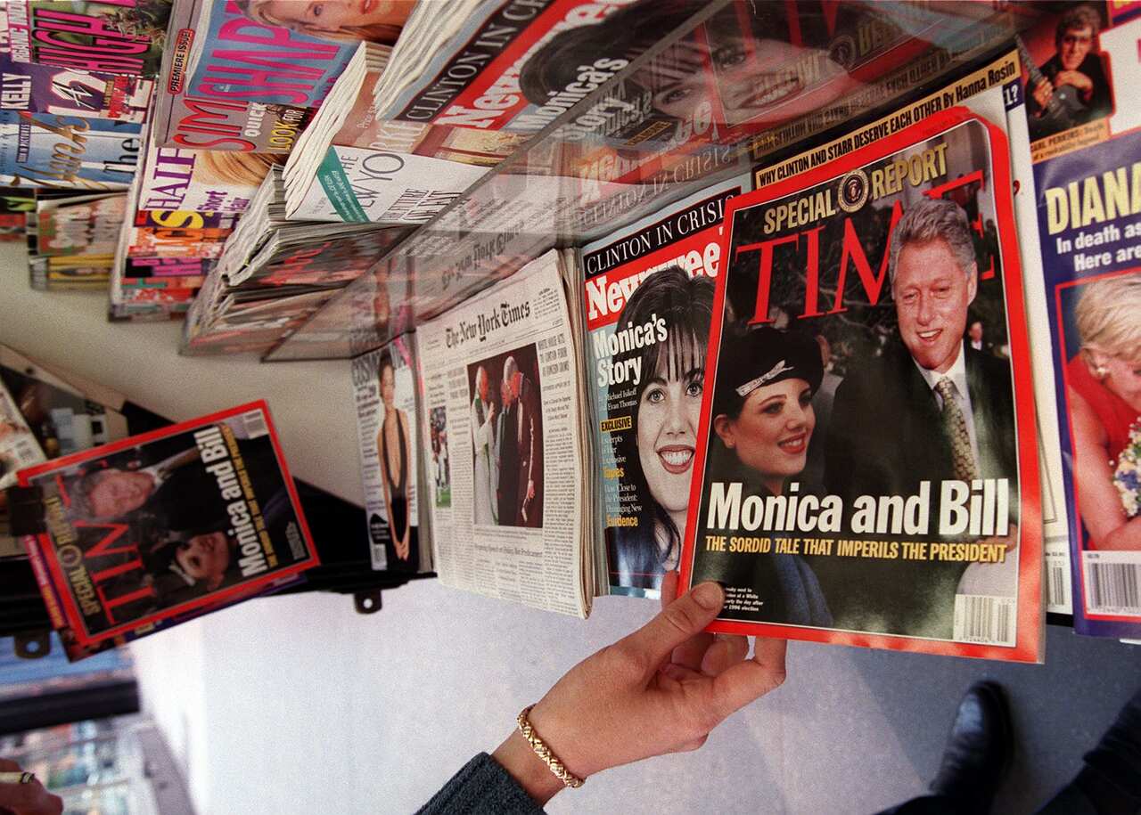 A woman reaches for a copy of Time Magazine.