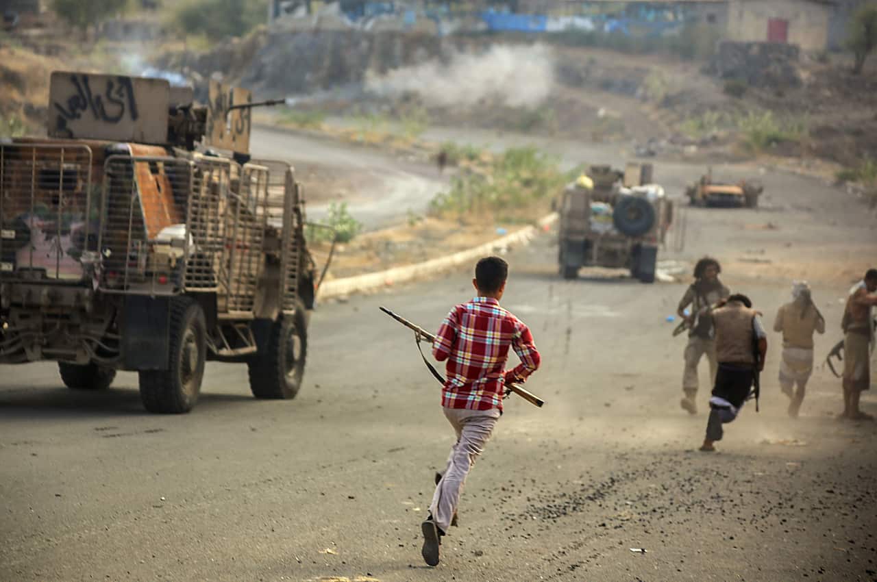 boy with gun, running, road, trucks