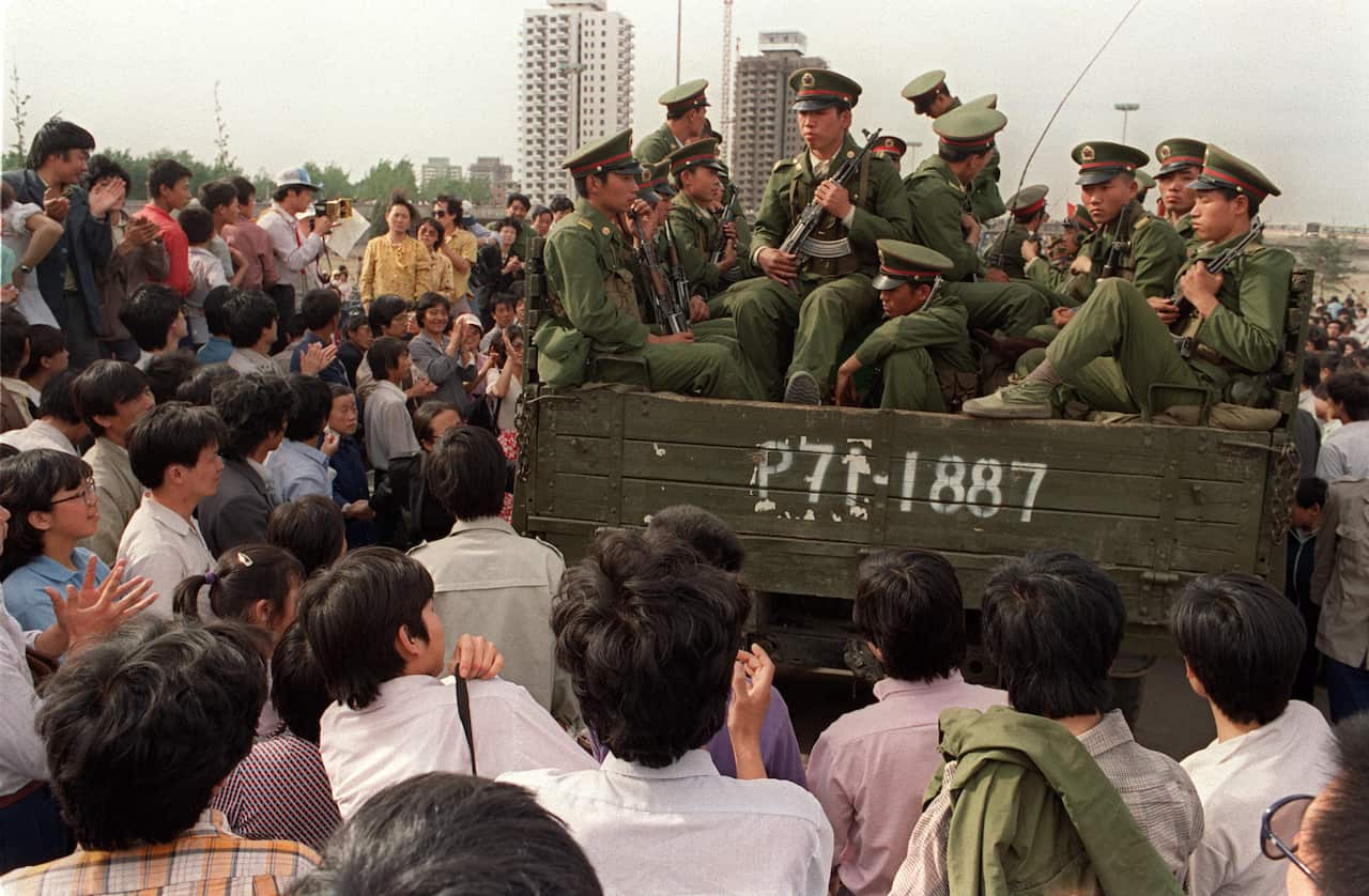 Pro-democracy demonstrators surround a truck fille
