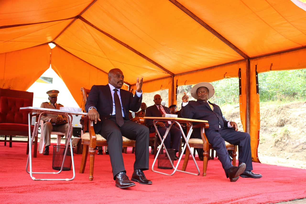 Ugandan President Yoveri Museveny (R) gestures as he sits under a marquee with Democratic Republic of Congo President Joseph Kabila.