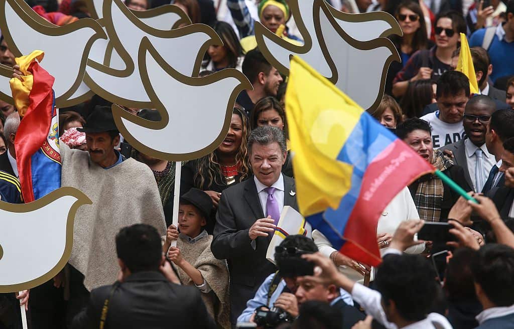 Colombian President Juan Manuel Santos (C) holds a copy with the final text of the peace agreement with the Revolutionary Armed Forces of Colombia (FARC).