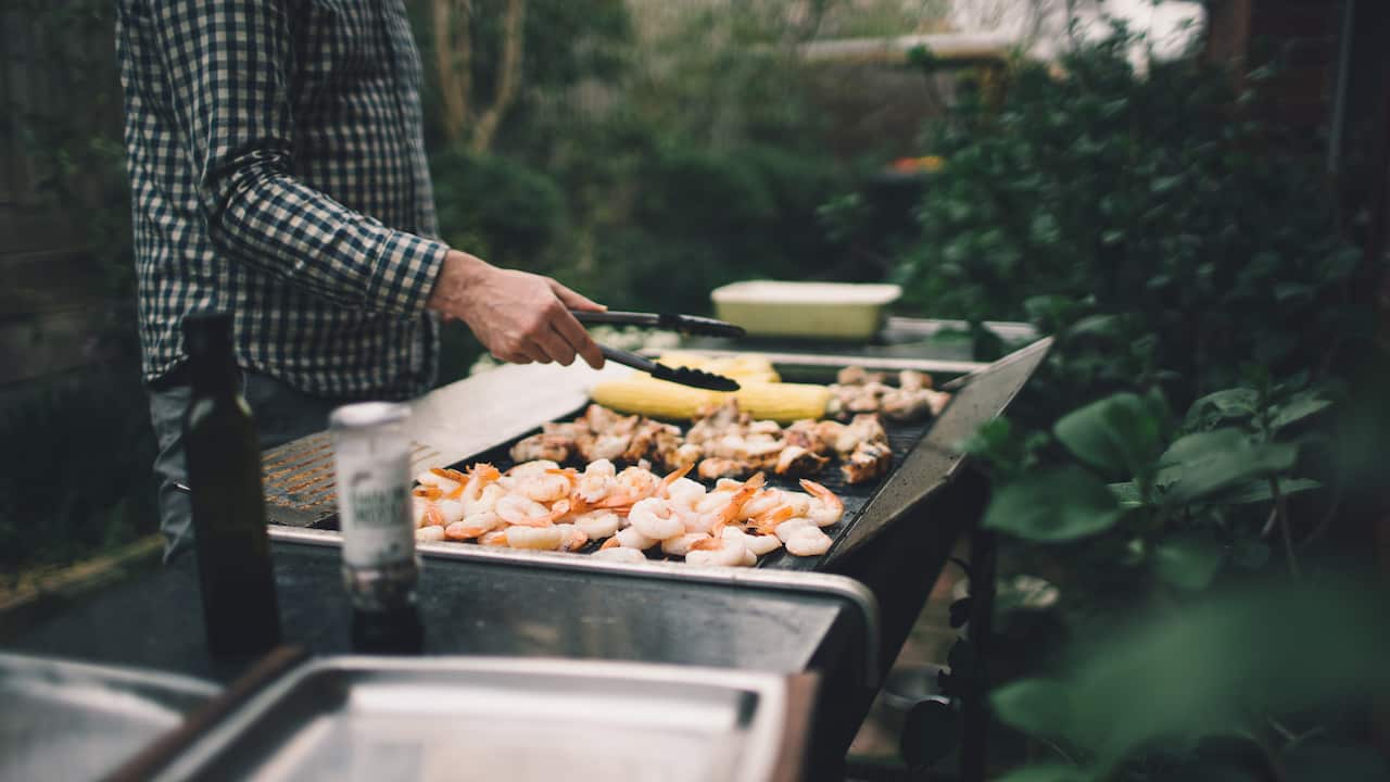 Man grills meat on BBQ