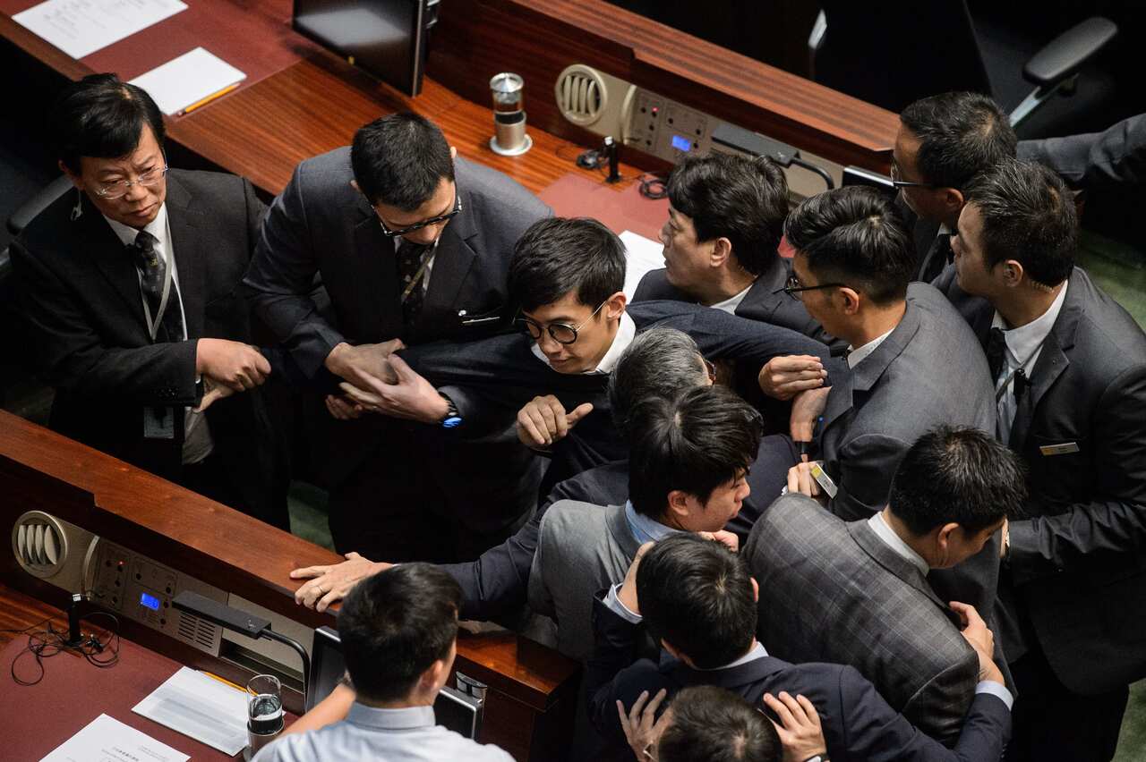 Newly elected lawmaker Baggio Leung (C) is restrained by security after attempting to read out his Legislative Council oath at Legco in Hong Kong on November 2, 2016.