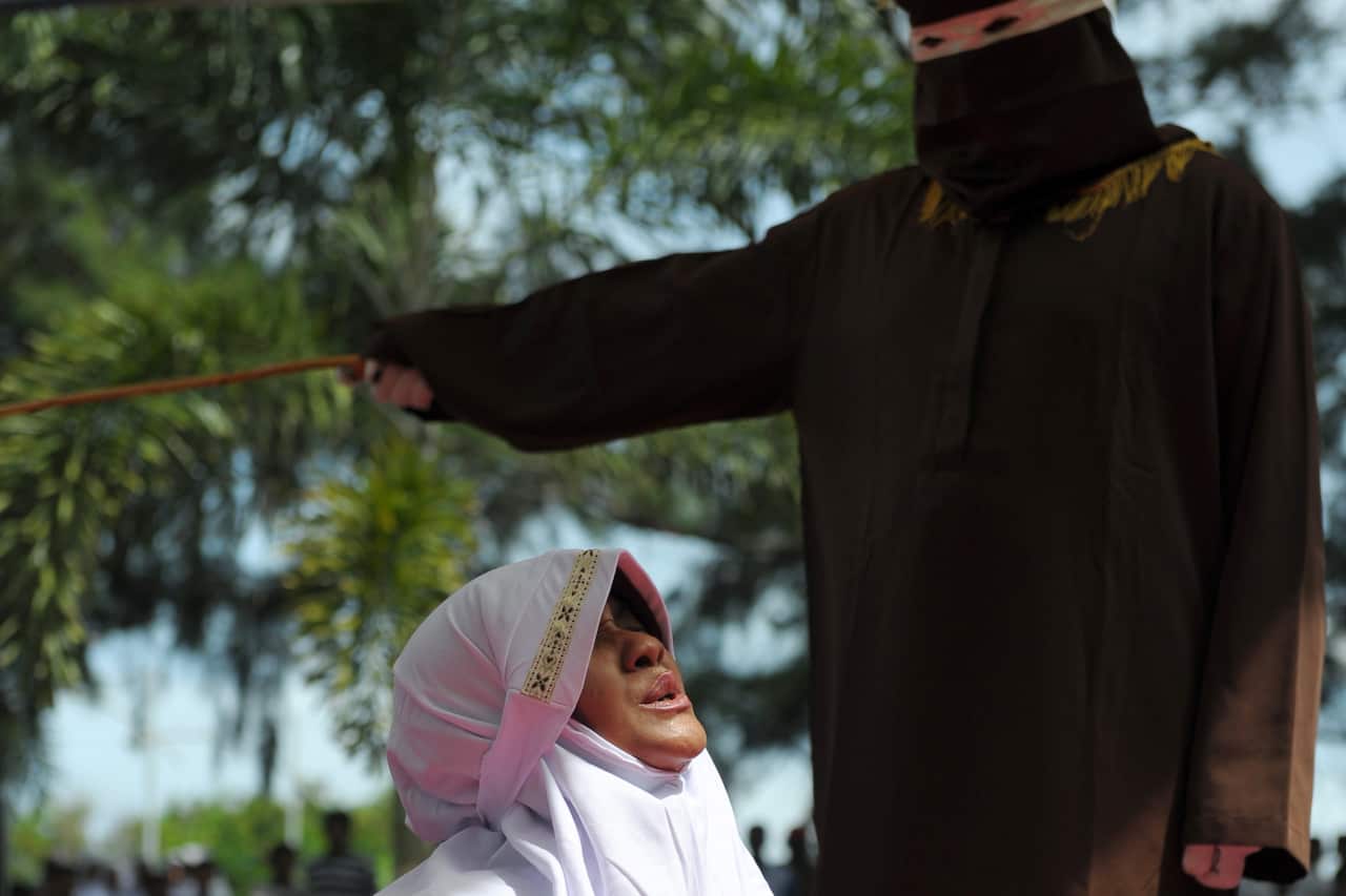 A religious officer canes an Acehnese woman for spending time in close proximity with a man who is not her husband.