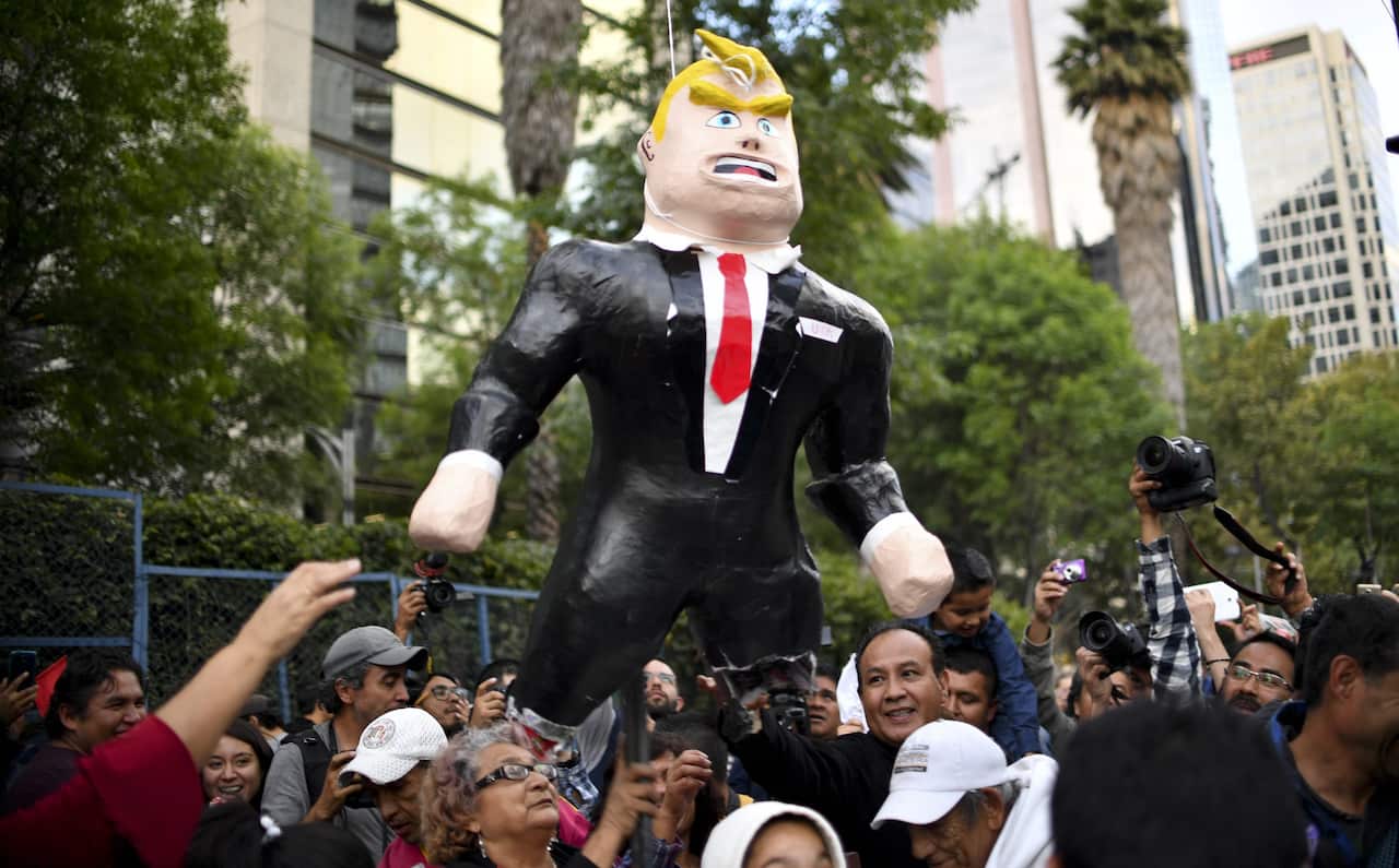 A pinata representing US President Donald Trump is broken during a protest against the US Embassy compound in Mexico City, on January 20, 2017.