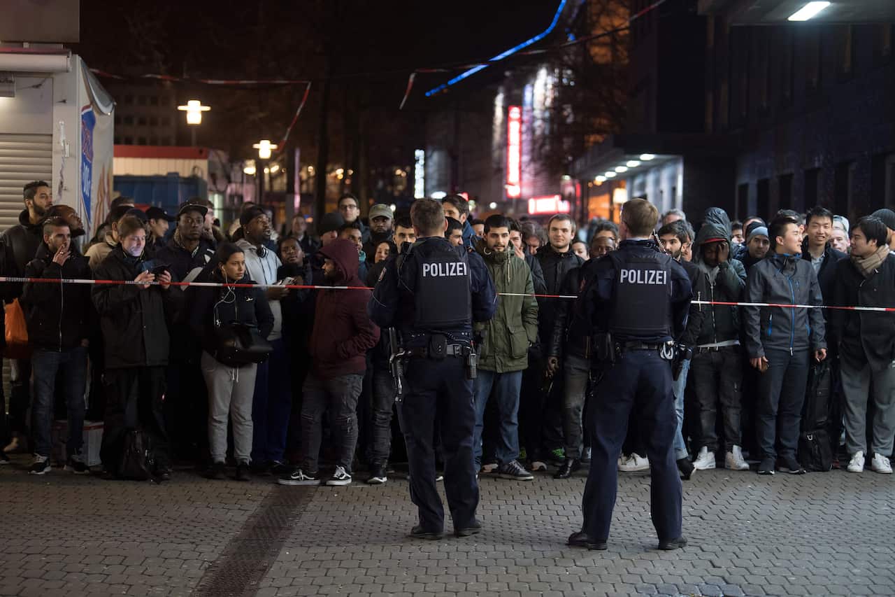 People stand behind a police cordon at the main train station in Duesseldorf March 9, 2017.