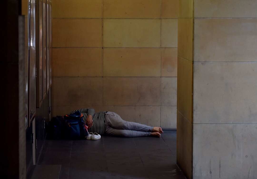 A woman sleeps in a doorway in Sydney's central business district.
