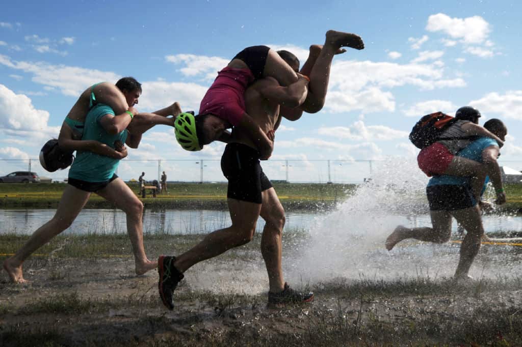 People take part in a wife-carrying championship during Viva Braslaw festival in the town of Braslaw, some 250 km north of Minsk on July 22, 2017. / AFP PHOTO / Sergei GAPON        (Photo credit should read SERGEI GAPON/AFP/Getty Images)