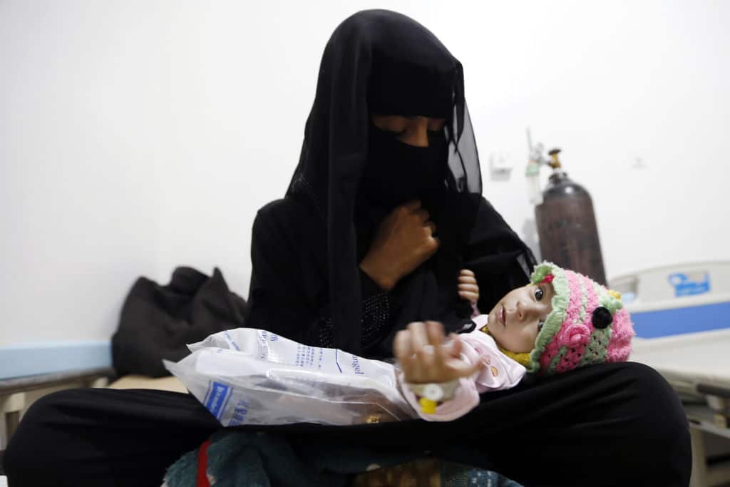 A Yemeni woman holds her child, who is suspected of being infected with cholera, at a makeshift hospital in Sana'a, August 2017.
