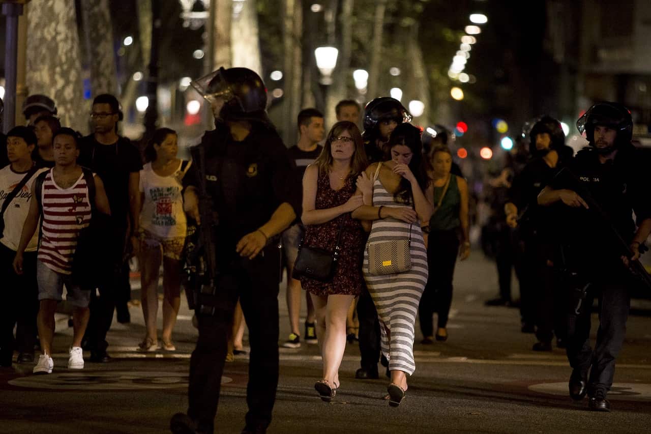 Police officers evacuate people from a shop at Las Ramblas as they take security measures after a van ploughs through a main street in Barcelona.