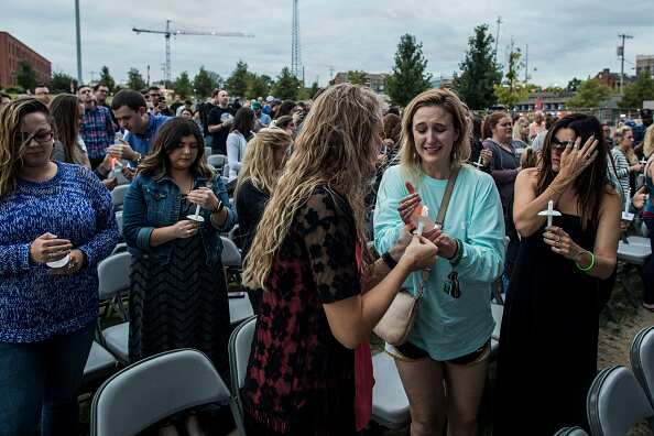 People light candles at the Ascend Amphitheater for a vigil honoring the victims of the mass shooting in Las Vegas on October 2, 2017 in Nashville, Tennessee. At least 58 people were killed and 500 wounded at the Route 91 Harvest Festival in Las Vegas.