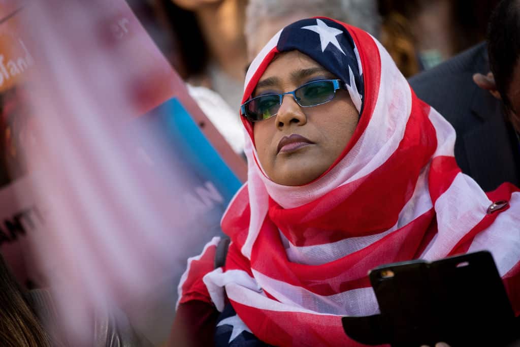 A woman wears a US flag headscarf at a protest against Donald Trump's proposed travel ban on 18 October 2017 in Washington DC.