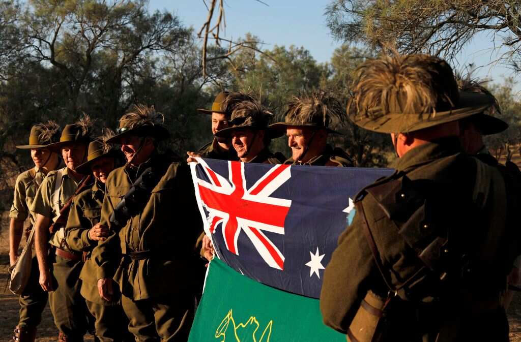 Members of the Australian Light Horse association wearing World War I uniforms hold their national flag