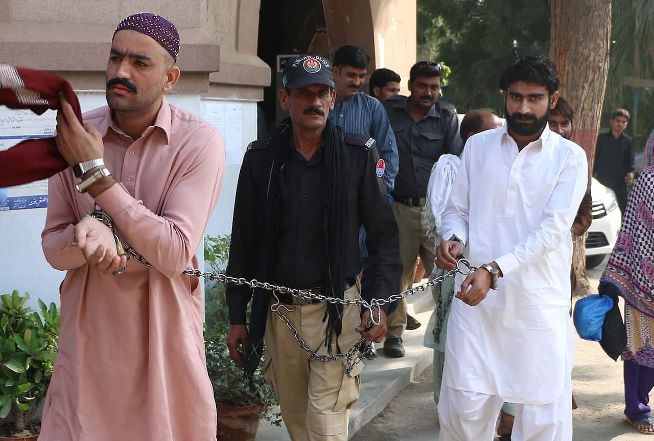 Wasim (R), brother of Qandeel Baloch and his cousin, who are accused of killing her, are escorted by policeman as they arrive at a local court in Multan.