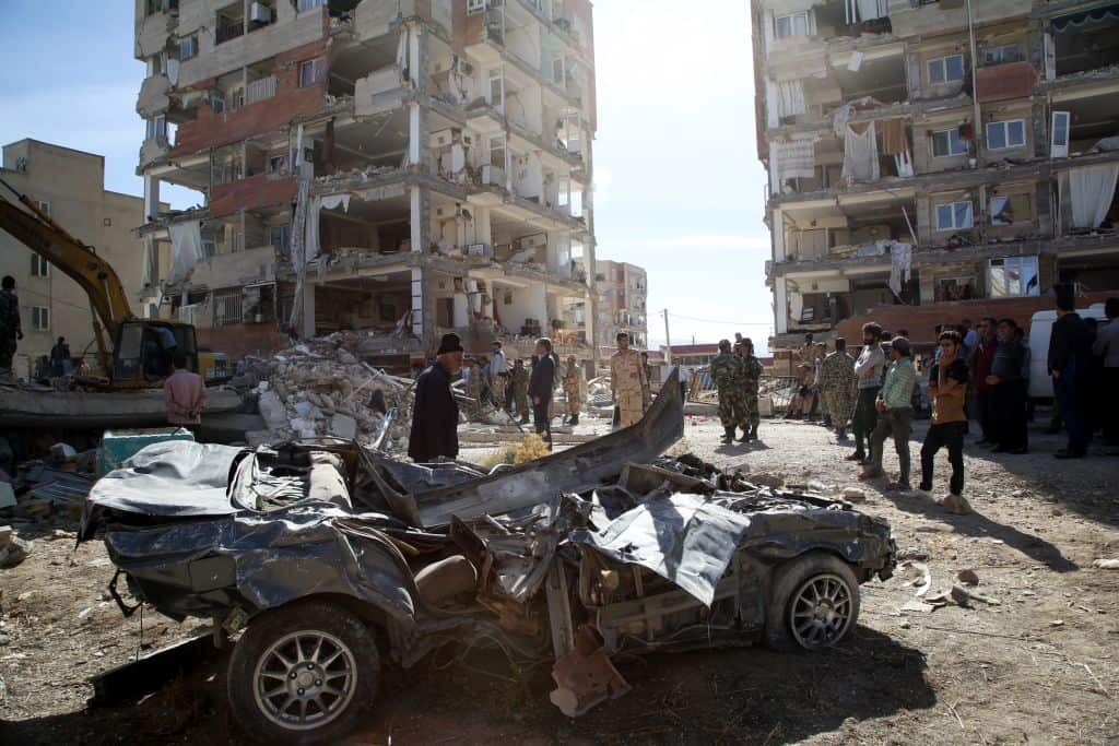 People inspect the debris of buildings and a destroyed vehicle at Sarpol-e Zahab province of Kermanshah, Iran on November 13, 2017 following a 7.3 magnitude earthquake.