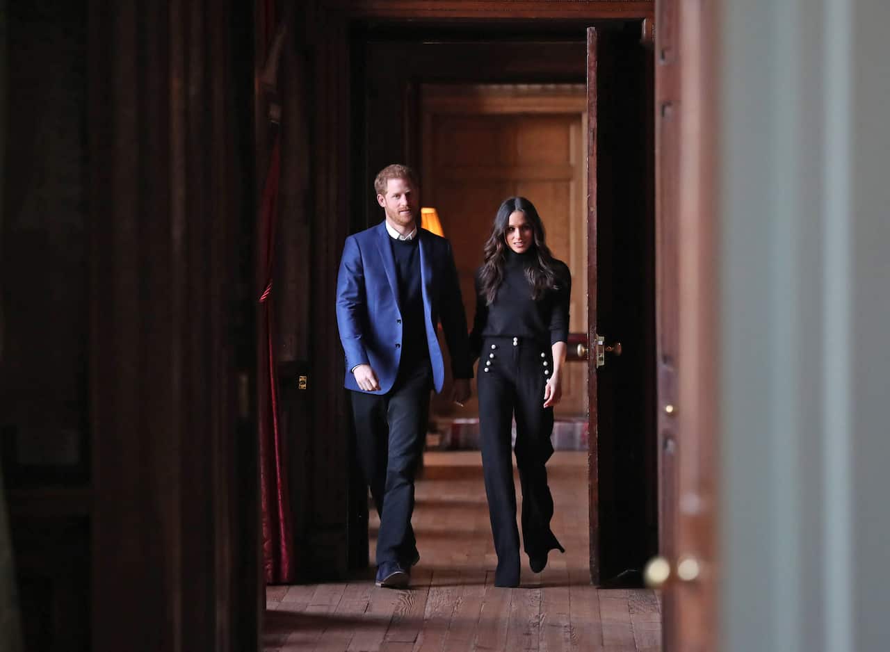 Prince Harry and Meghan Markle walk through the corridors of the Palace of Holyroodhouse.